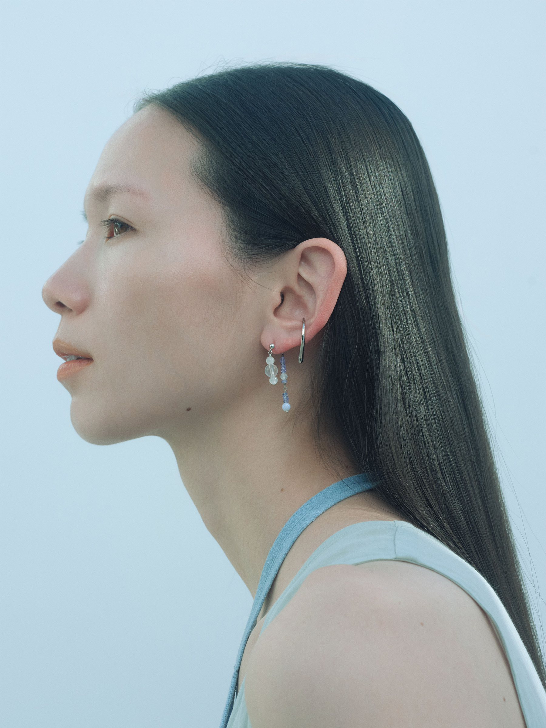 「Asymmetry」コレクションのピアスとプラチナカラーのイヤーカフを着用したモデル