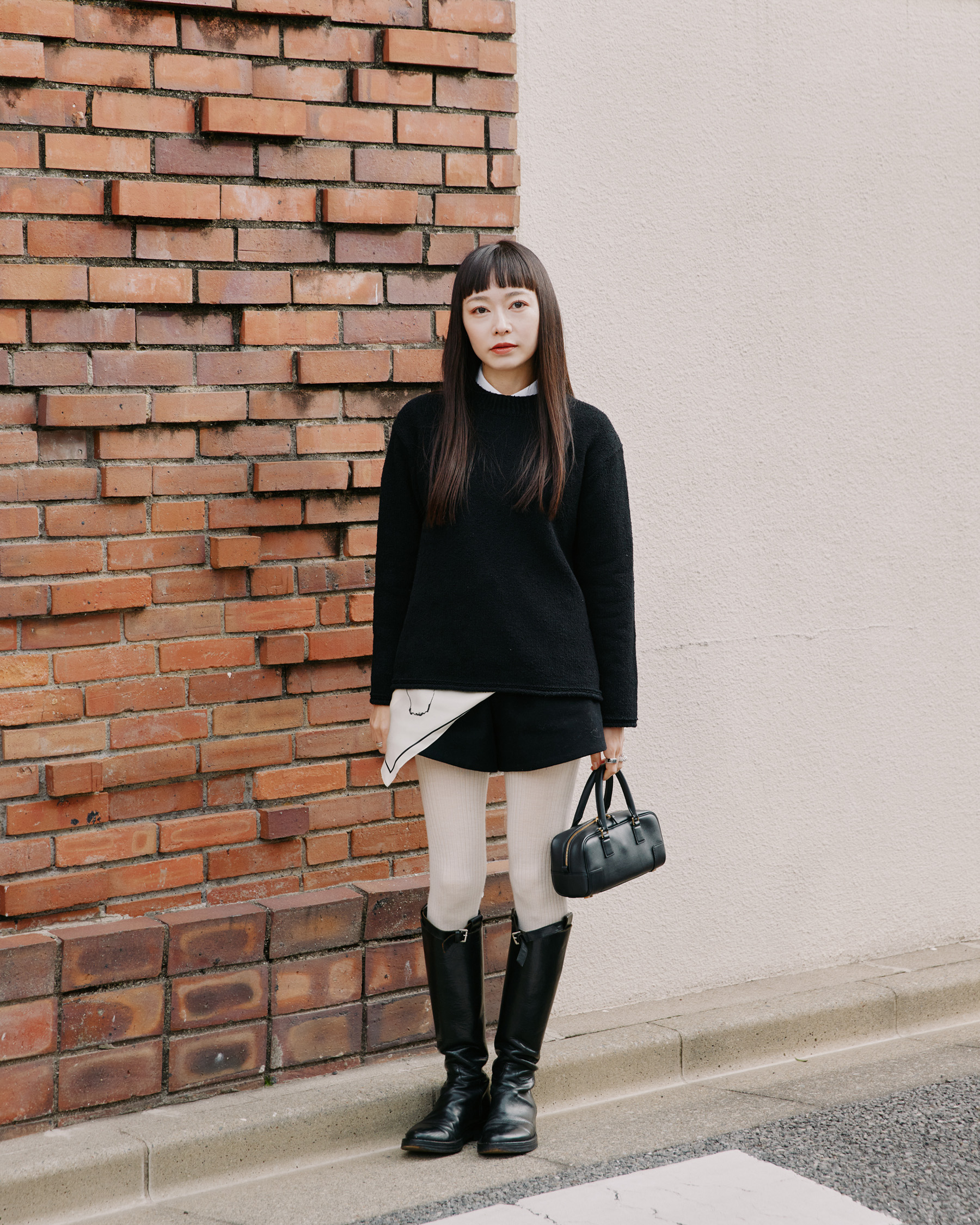 写真: ベーシックな黒ニットに、ミニスカートとロングブーツでシックなブラックスタイルが完成した市川さん