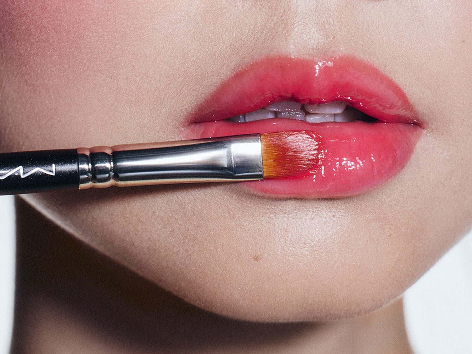 写真:唇にリップブラシでメイクしている画像