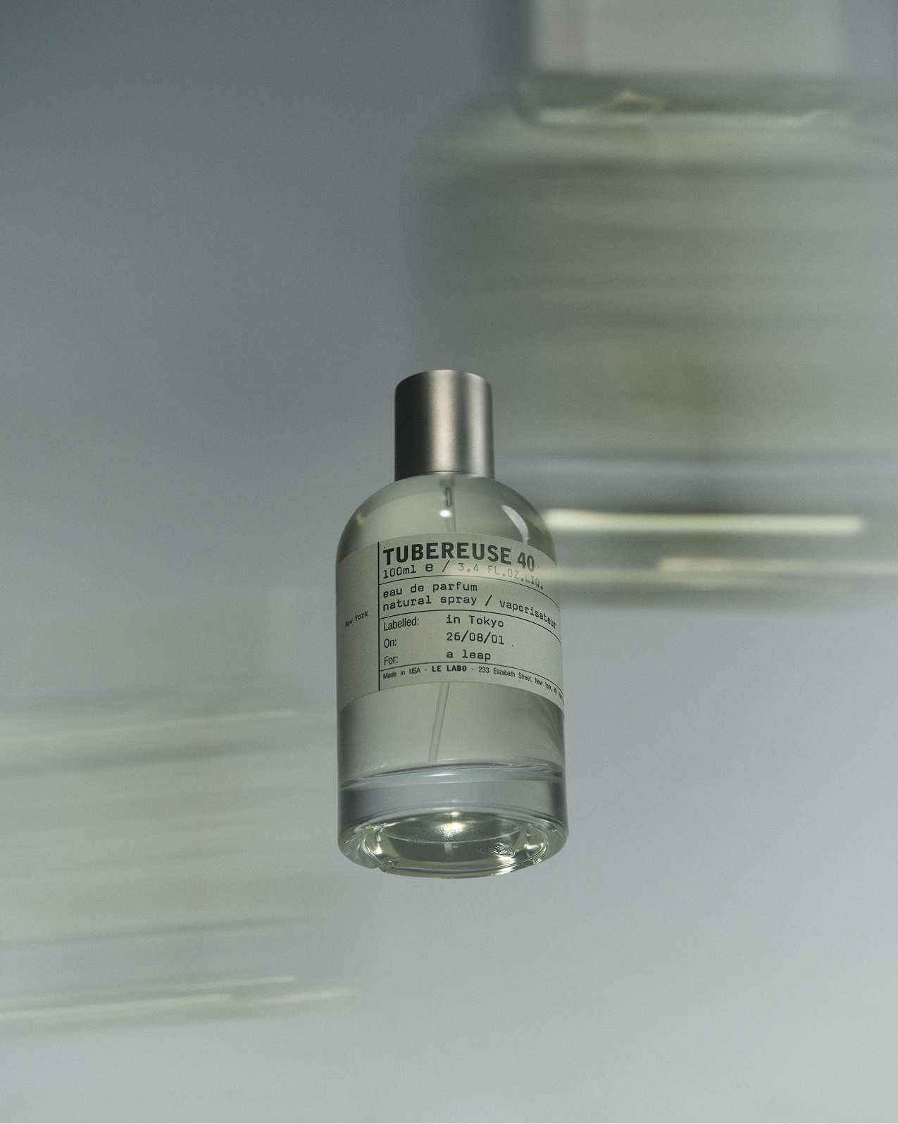 写真: Le Labo TUBEREUSE 40の香水ボトルがミニマルな背景の前に置かれている